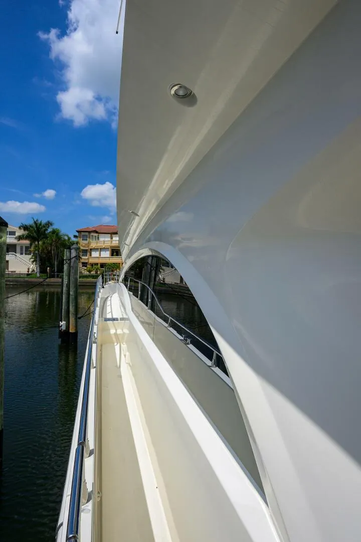 Slide: The Image of Side view of 2005 Marquis 65 MY yacht docked by waterfront homes. - 45