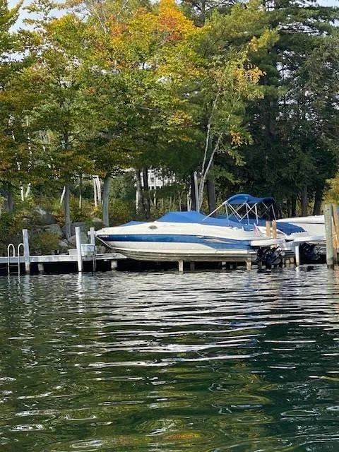Slide: The Image of 2003 Sea Ray 240 Sundeck docked by a scenic lakeside with autumn trees. - 11