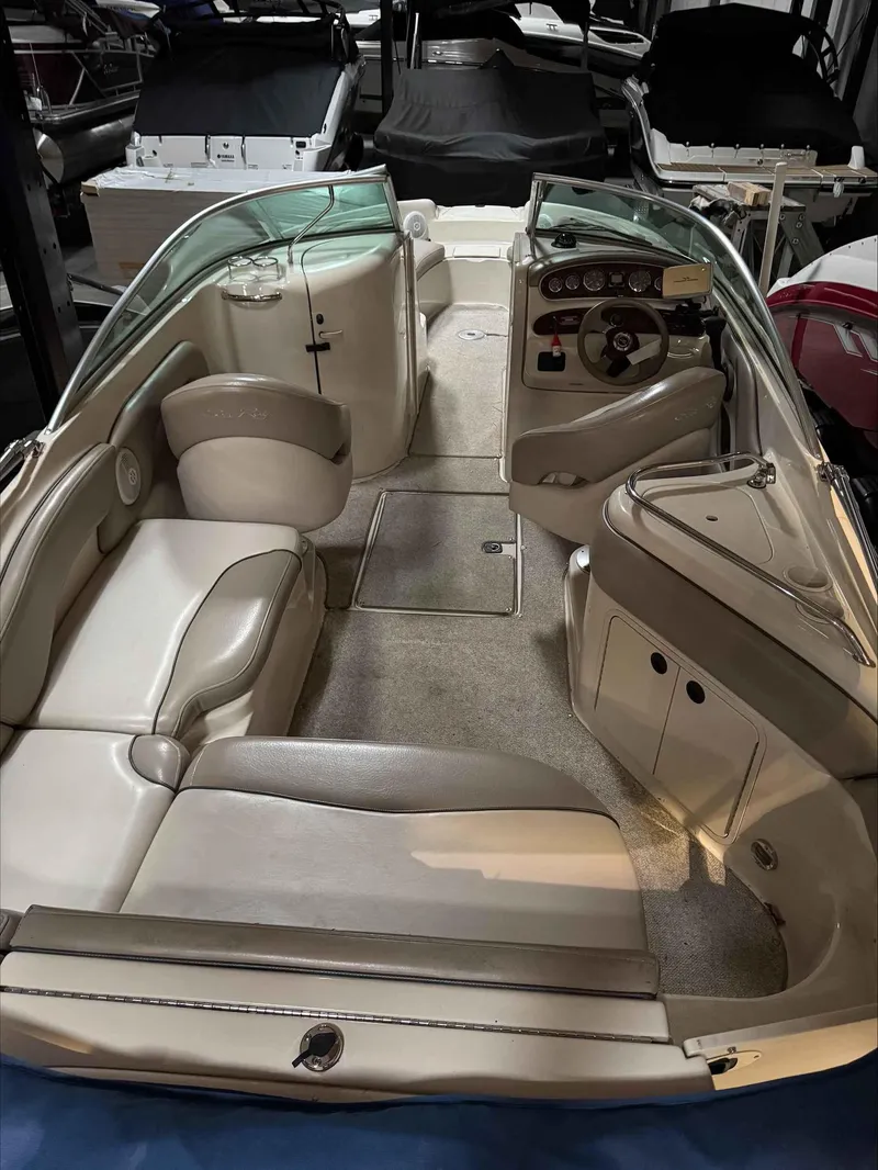Slide: The Image of 2003 Sea Ray 240 Sundeck interior with beige seating and dashboard. - 17
