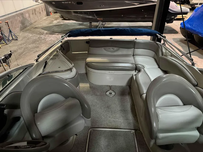 Slide: The Image of 2003 Sea Ray 240 Sundeck interior with gray seating and carpeted floor. - 18
