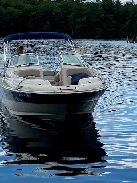 Slide: The Image of 2003 Sea Ray 240 Sundeck boat on a calm lake with trees in the background. - 5