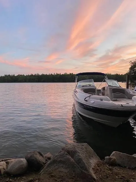 Slide: The Image of 2003 Sea Ray 240 Sundeck boat on serene lake at sunset. - 6