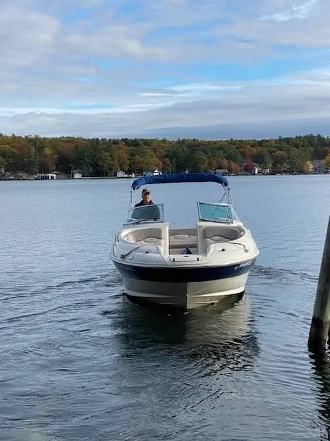 Slide: The Image of 2003 Sea Ray 240 Sundeck boat on a calm lake with scenic background. - 9