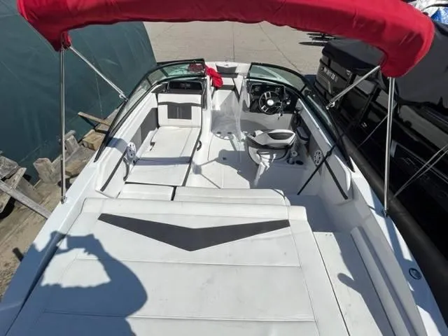 Slide: The Image of 2022 Monterey M22 boat interior with red canopy, white seating, and steering wheel. - 12