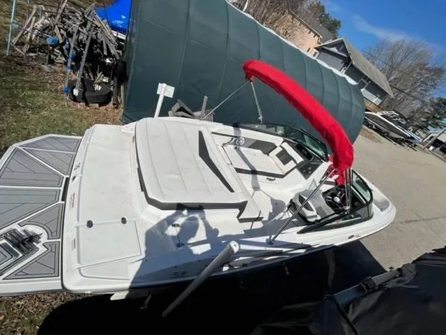 Slide: The Image of 2022 Monterey M22 boat with red canopy, parked outdoors near a green shelter. - 13