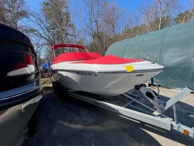 Slide: The Image of 2022 Monterey M22 boat with red cover on trailer, parked outdoors. - 3