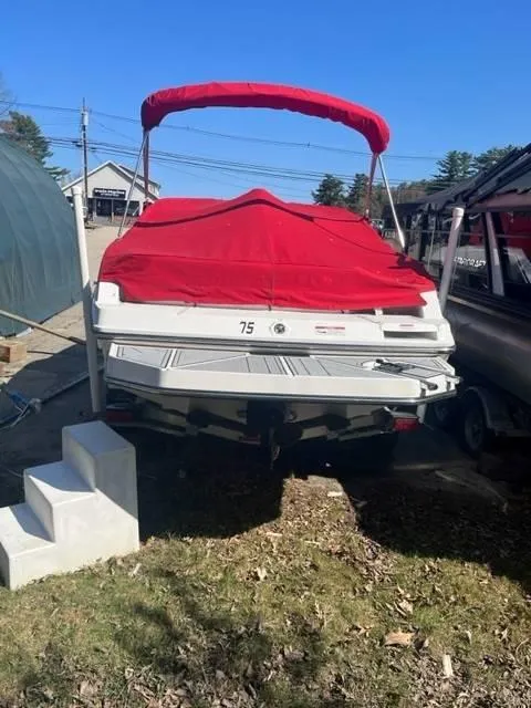 Slide: The Image of 2022 Monterey M22 boat with red cover, parked outdoors. - 4