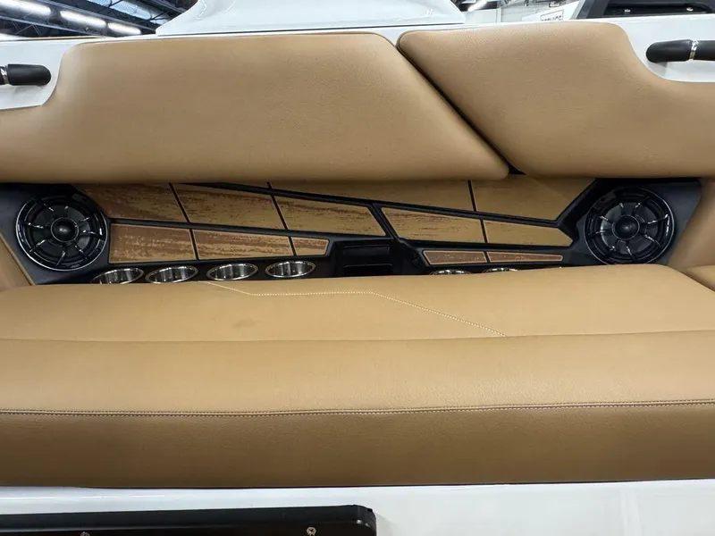 Slide: The Image of 2025 Moomba Max boat interior with tan seating, speakers, and cup holders. - 10