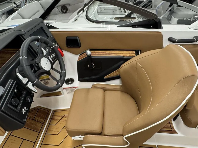 Slide: The Image of 2025 Moomba Max boat interior with tan leather seat and modern steering wheel. - 12