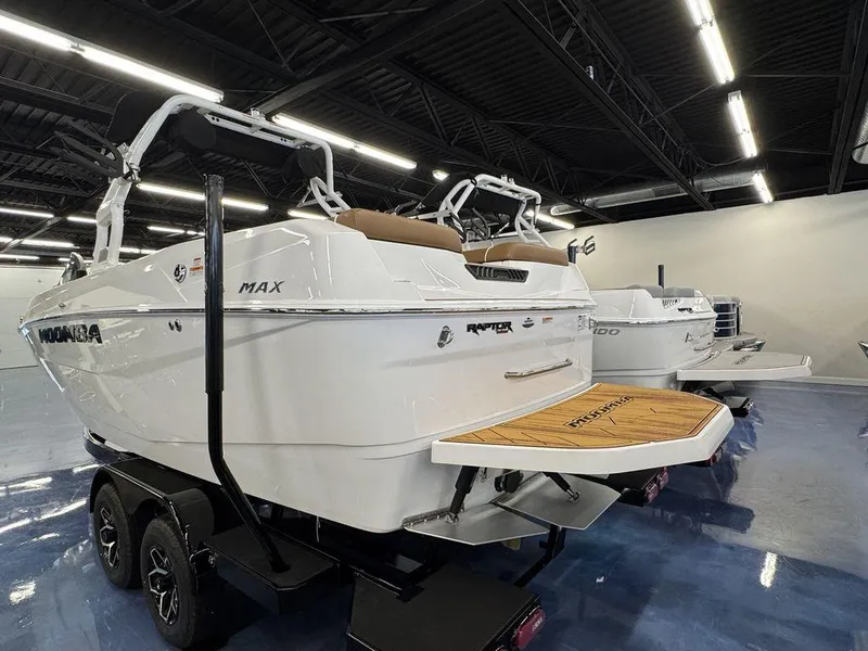 Slide: The Image of 2025 Moomba Max boat in showroom, featuring sleek design and dual-axle trailer. - 3