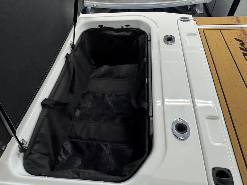 Slide: The Image of 2025 Moomba Max boat storage compartment with open lid and black interior. - 6