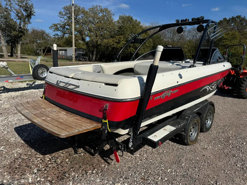 Slide: The Image of 2003 Malibu Wakesetter 23 XTi boat on trailer, red and white design, parked outdoors. - 2