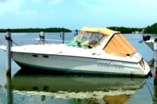 Slide: The Image of 1988 Wellcraft Gran Sport boat docked on calm water with orange canopy. - 12