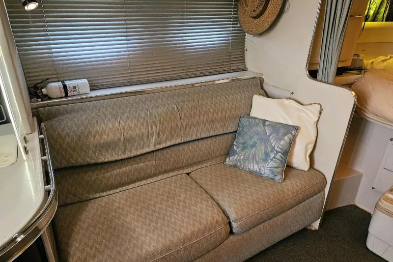 Slide: The Image of Interior of 1988 Wellcraft Gran Sport with cozy sofa and decorative pillows. - 15
