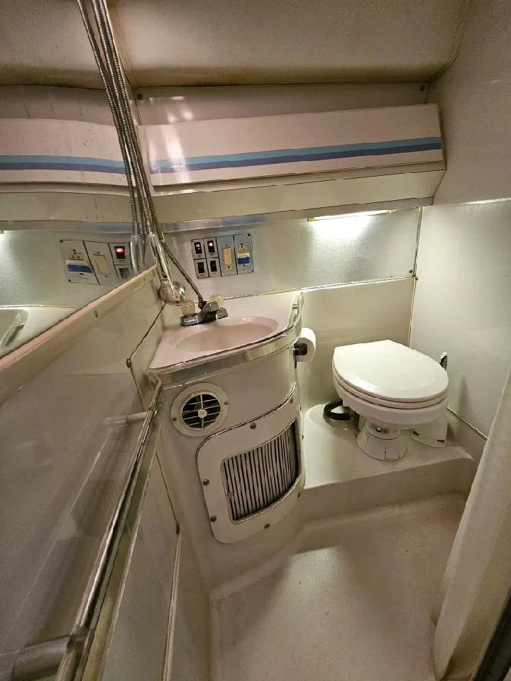 Slide: The Image of 1988 Wellcraft Gran Sport boat bathroom with sink, toilet, and storage. - 4