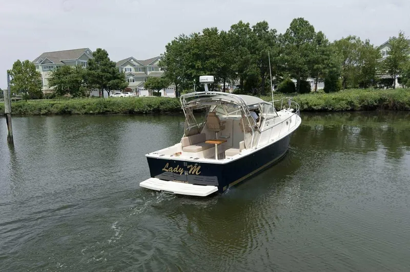 Slide: The Image of 2004 Mainship Pilot 30-II boat named "Lady M" on a calm river. - 2