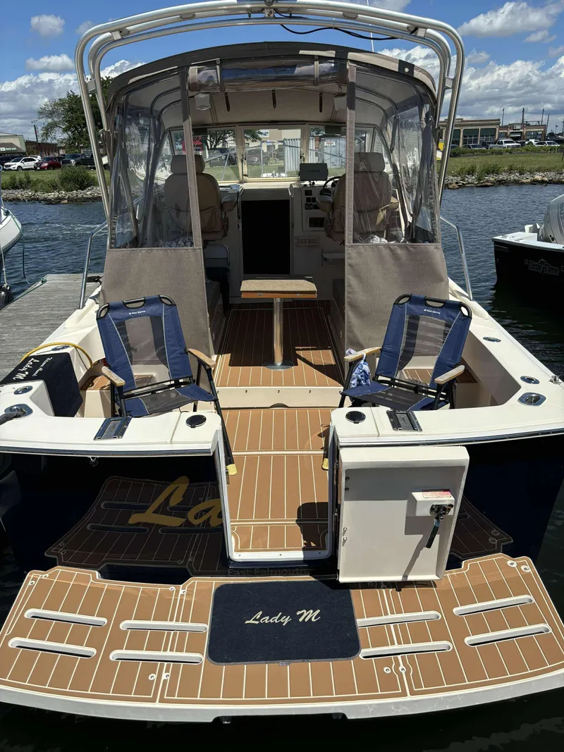 Slide: The Image of 2004 Mainship Pilot 30-II boat with seating and canopy, docked on a sunny day. - 4