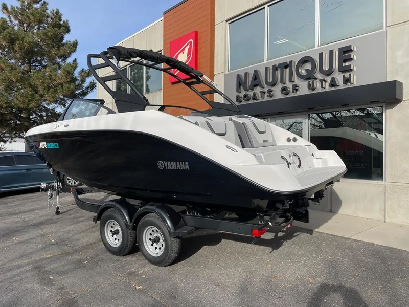 Slide: The Image of 2025 Yamaha AR220 boat on trailer outside Nautique dealership. - 3