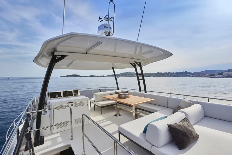 Slide: The Image of Luxury Prestige M48 yacht deck with seating, table, and ocean view, 2025 model. - 11