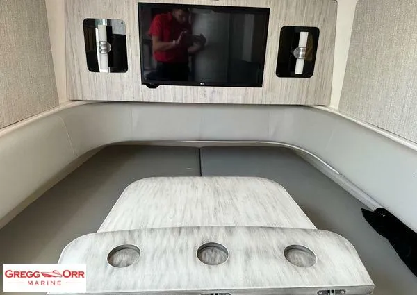 Slide: The Image of 2021 Regulator 41 interior with seating, table, and TV in a modern marine setting. - 25