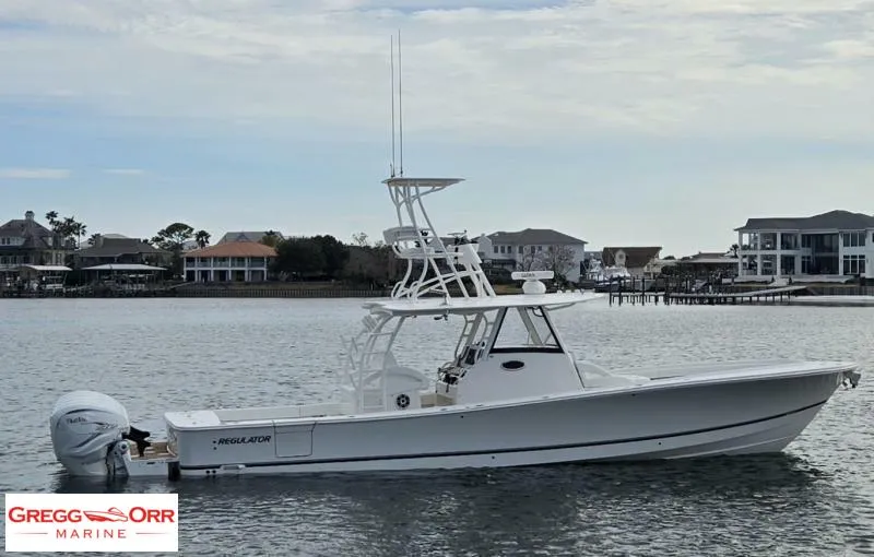 Slide: The Image of 2021 Regulator 41 boat on water, side view, with coastal homes in the background. - 4