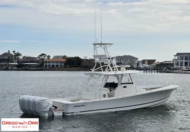 Slide: The Image of 2021 Regulator 41 boat on water, featuring multiple outboard engines, with coastal homes in the background. - 5