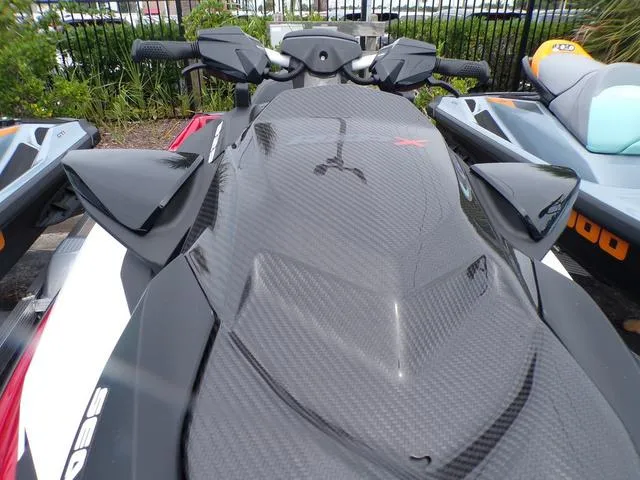 Slide: The Image of 2024 Sea-Doo Waverunner RXP-X 325 in Fiery Red, sleek design, parked outdoors. - 5