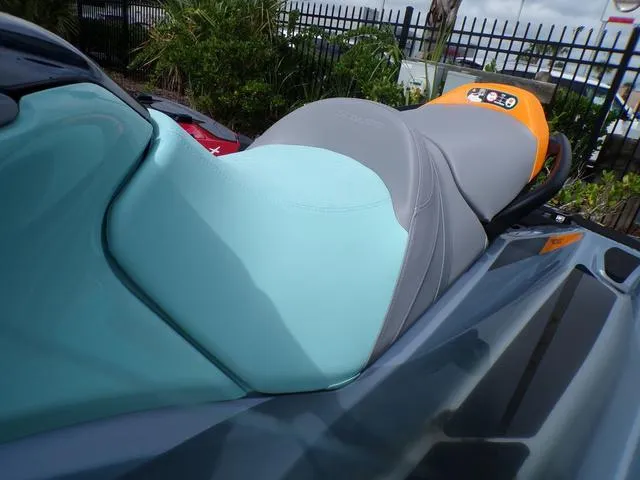 Slide: The Image of 2024 Sea-Doo Waverunner GTI with teal and gray seat, parked outdoors. - 16