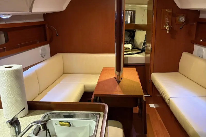 Slide: The Image of Interior of 2013 Beneteau Oceanis 34 sailboat with cozy seating and wooden finishes. - 15