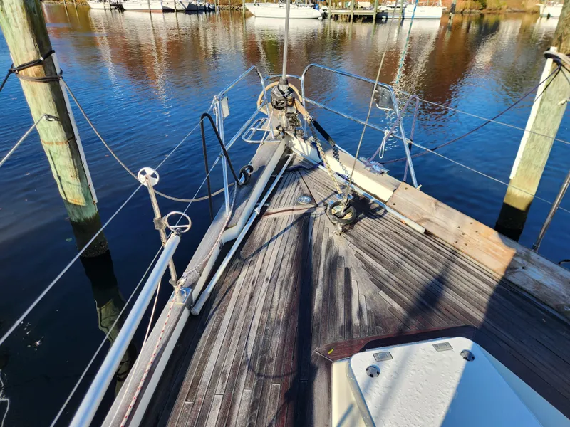 Slide: The Image of Bow of a 2000 Regina 43 sailboat docked on calm water. - 11