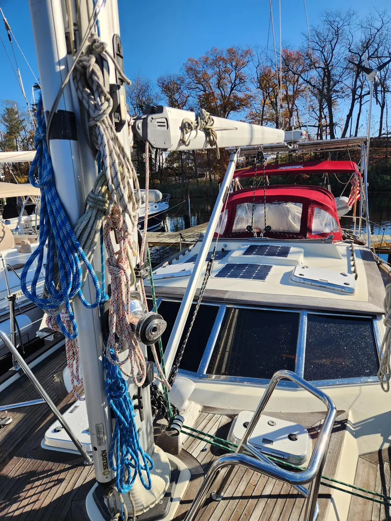 Slide: The Image of Sailboat deck with ropes and mast, Regina 43 model, 2000, docked under clear blue sky. - 13