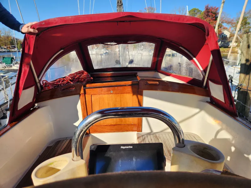 Slide: The Image of Cockpit of a 2000 Regina 43 sailboat with red canopy and wooden accents. - 14