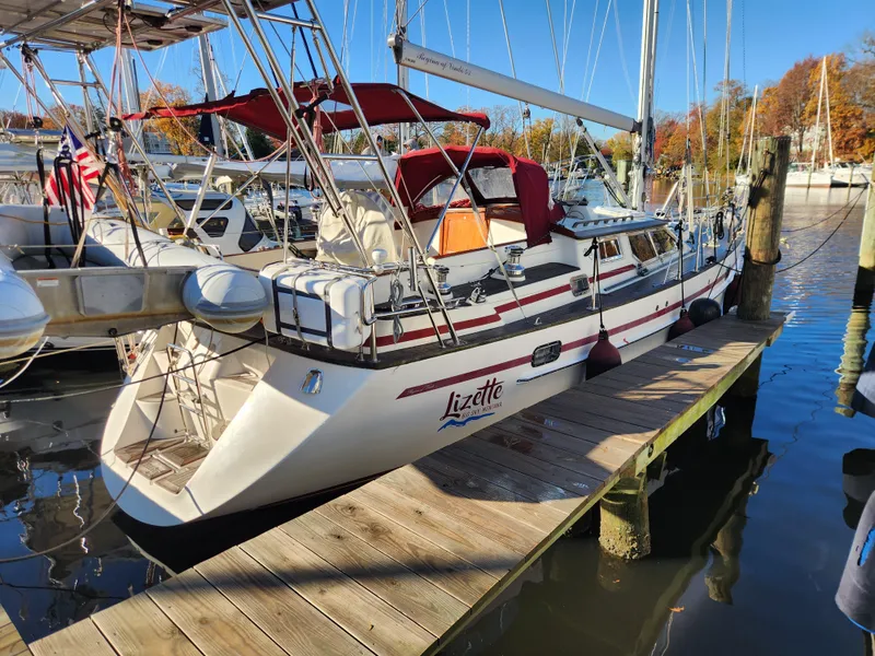 Slide: The Image of Sailboat "Lizette" docked, Regina 43 model, 2000, with red canopy and American flag. - 19