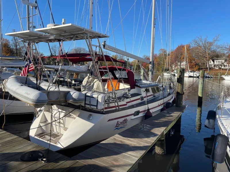 Slide: The Image of Sailboat docked at marina, Regina 43 model, year 2000, with clear blue sky. - 2