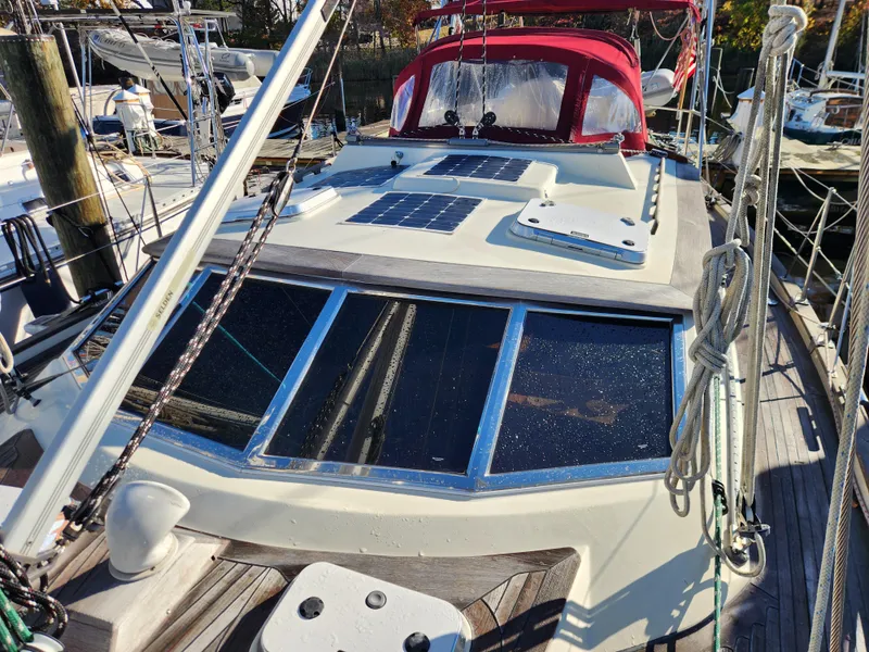 Slide: The Image of Sailboat Regina 43, 2000 model, docked with solar panels and red canopy. - 20