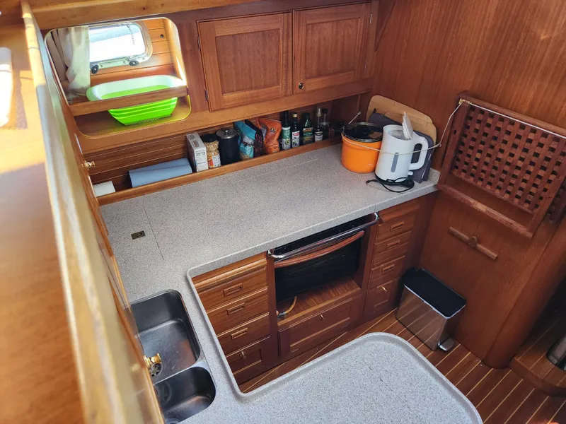 Slide: The Image of Compact kitchen in a 2000 Regina 43 yacht with wooden cabinets and modern appliances. - 29