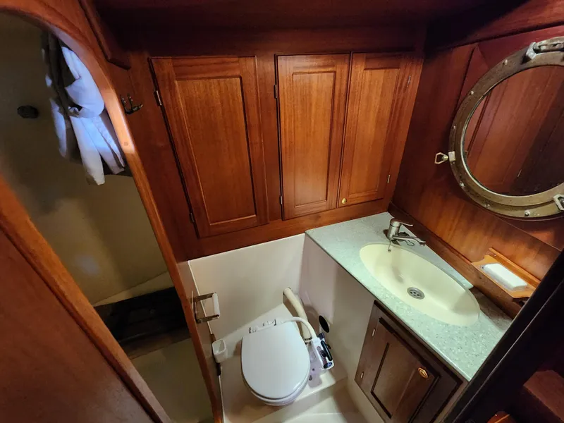 Slide: The Image of Wooden boat bathroom with sink, toilet, and porthole window. Regina 43, year 2000. - 30