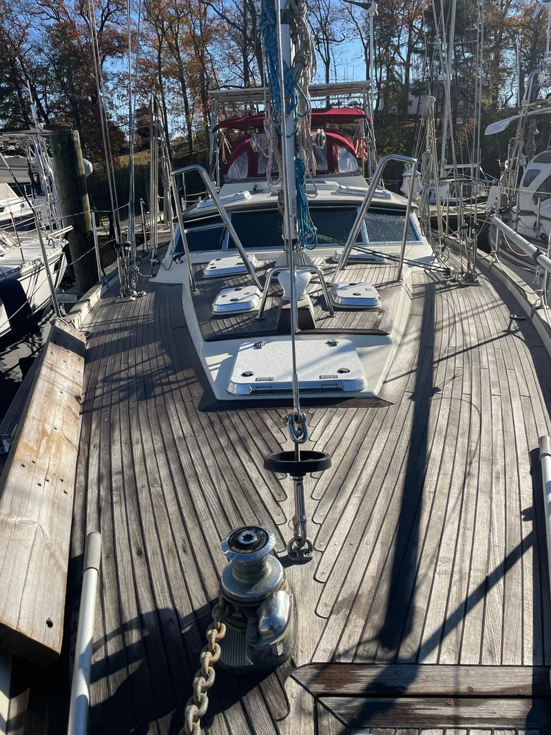 Slide: The Image of Sailboat deck of a 2000 Regina 43, featuring wooden planks and metal fittings. - 32