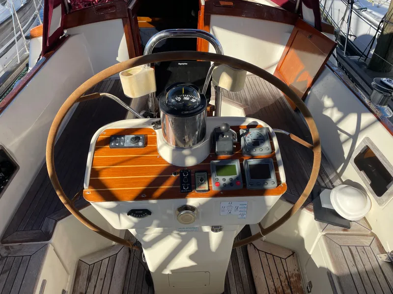 Slide: The Image of Cockpit of a 2000 Regina 43 sailboat with wooden steering wheel and navigation instruments. - 45