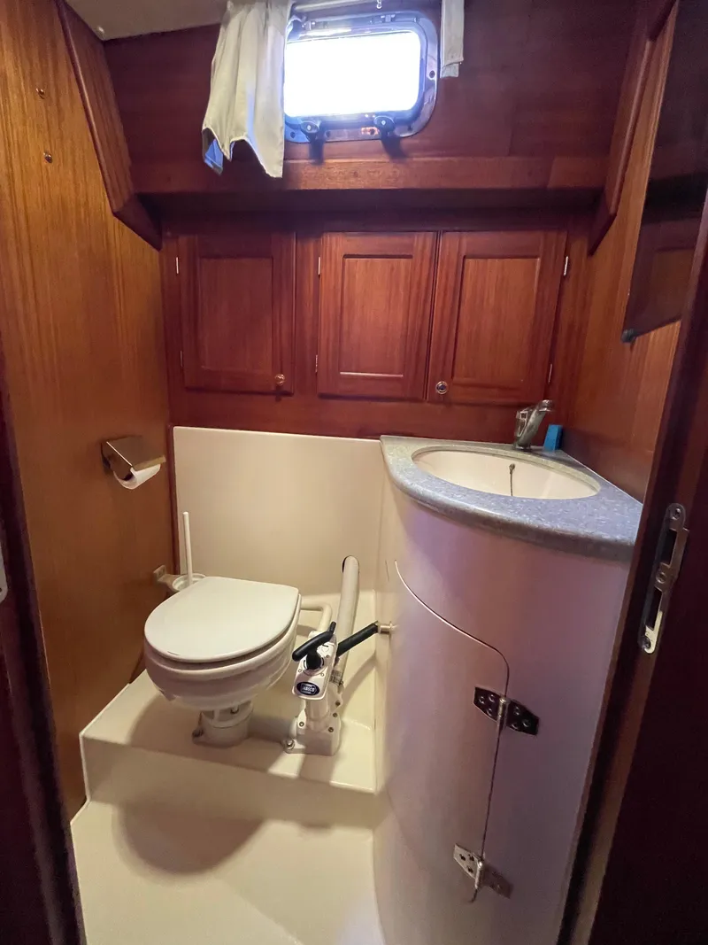 Slide: The Image of Wood-paneled boat bathroom with toilet and sink, Regina 43, year 2000 model. - 47