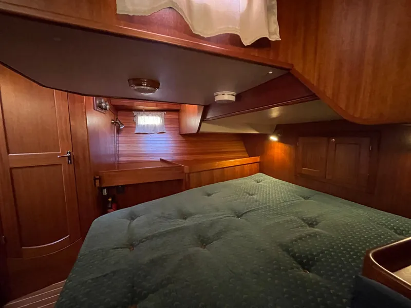 Slide: The Image of Cozy cabin interior of 2000 Regina 43 yacht with wooden finish and green bedding. - 48