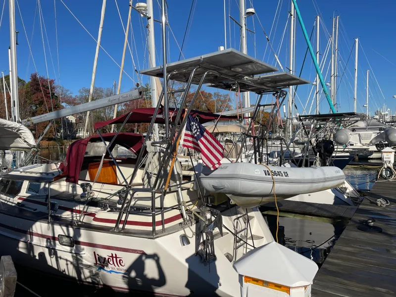Slide: The Image of Sailboat docked at marina, Regina 43 model, 2000, with American flag and dinghy. - 5