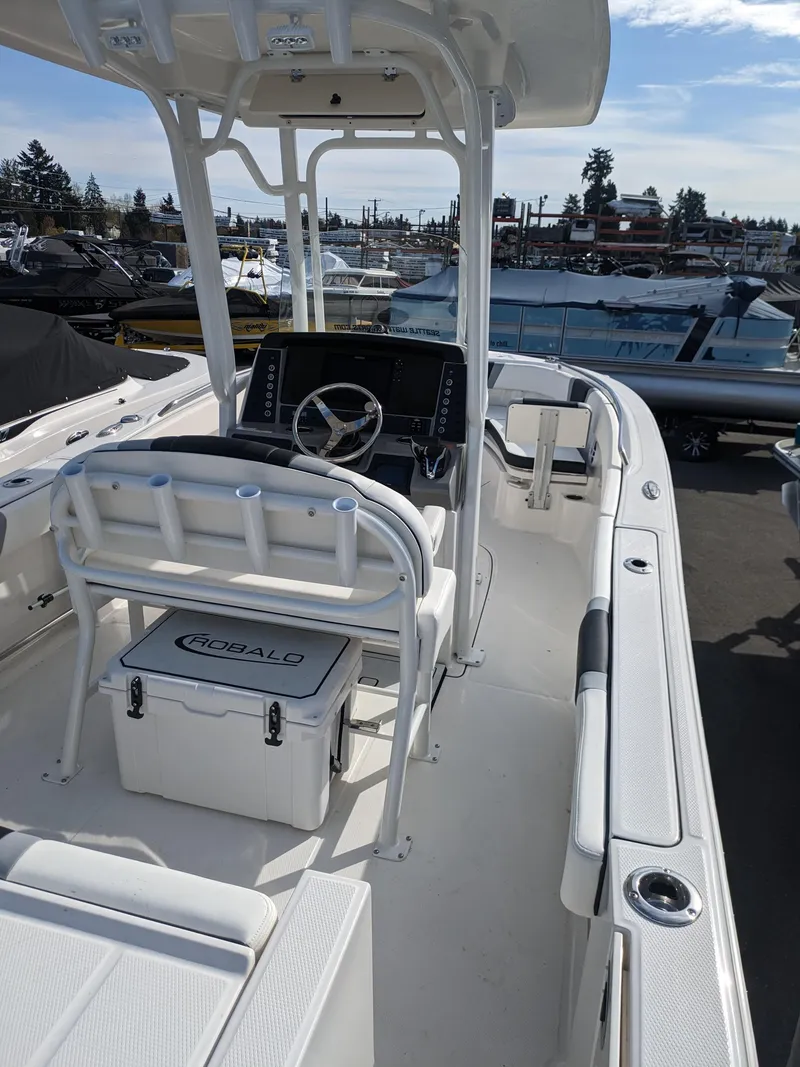 Slide: The Image of 2025 Robalo R230 Center Console boat with sleek design, docked in a marina. - 18
