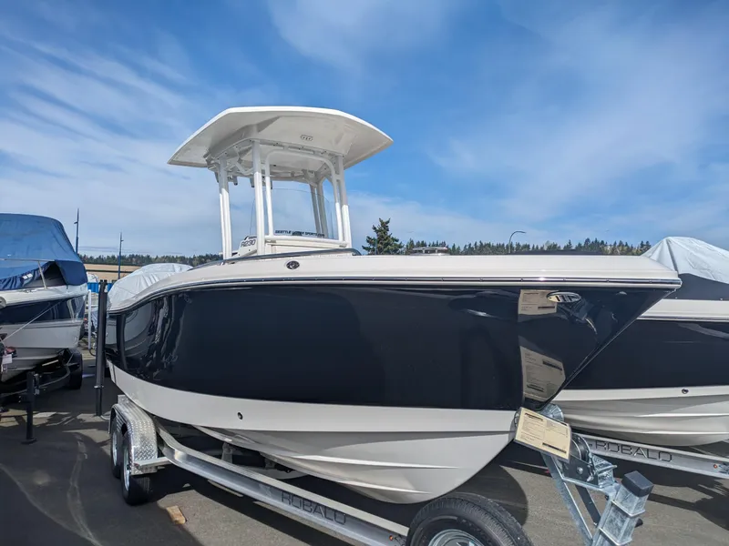 Slide: The Image of 2025 Robalo R230 Center Console boat on trailer under blue sky. - 2