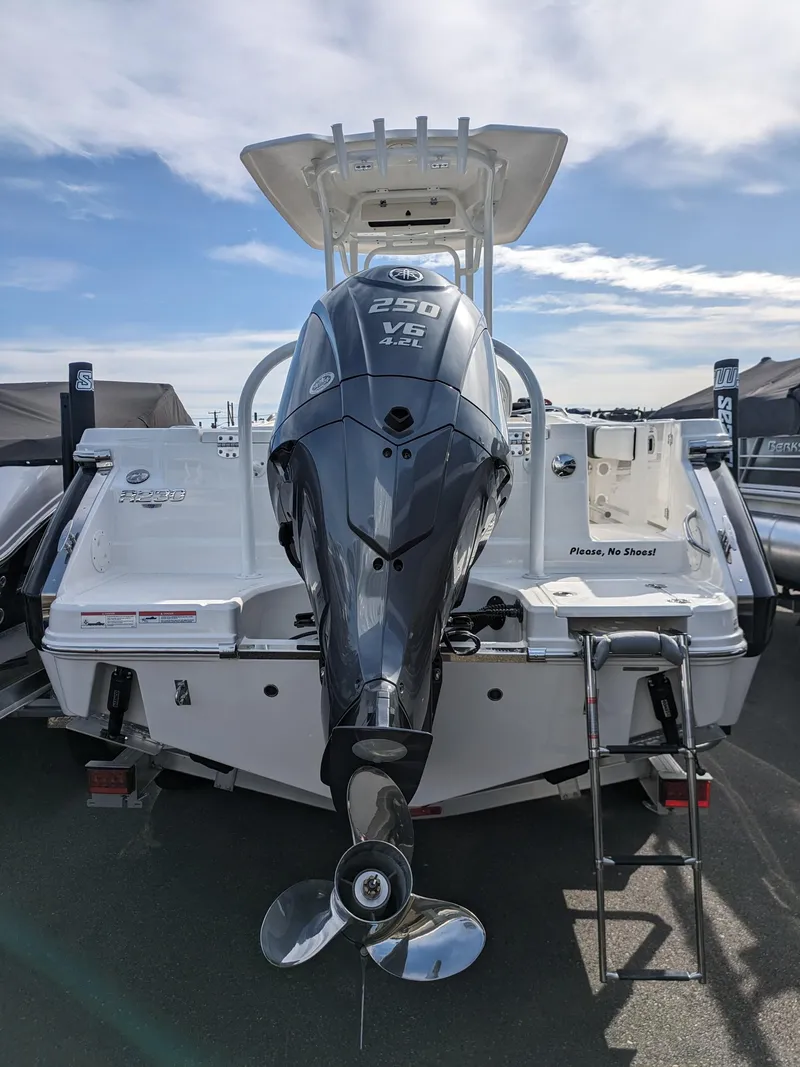 Slide: The Image of 2025 Robalo R230 Center Console boat with powerful outboard motor, docked under clear skies. - 26