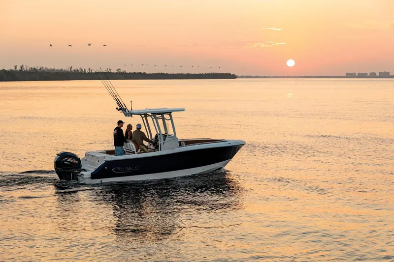 Slide: The Image of 2025 Robalo R230 Center Console boat cruising at sunset on calm waters. - 4