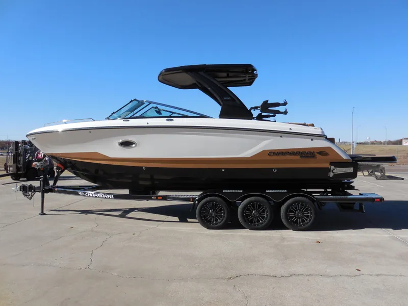 Slide: The Image of 2025 Chaparral 30 Surf boat on trailer, side view, clear sky background. - 6