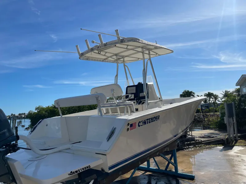 Slide: The Image of 2004 Contender 21 Open boat on stand, clear sky, waterfront view. - 2
