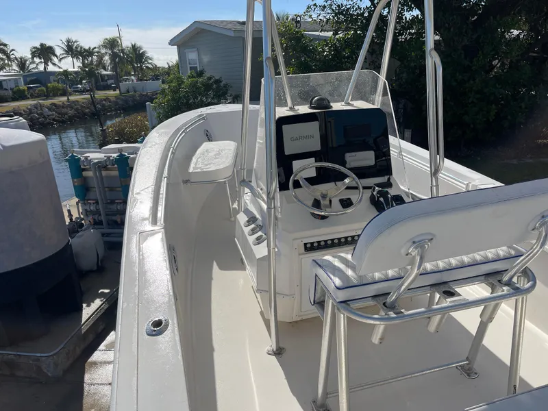 Slide: The Image of 2004 Contender 21 Open boat with steering console, docked near waterfront homes. - 5
