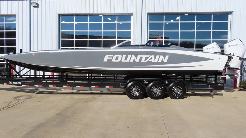 Slide: The Image of 2023 Fountain 34 Thundercat powerboat on trailer, sleek design, parked outside a garage. - 1